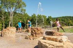 kids playing in water squirting from rocks