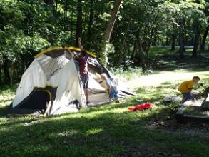 Kids playing by a tent at a campground
