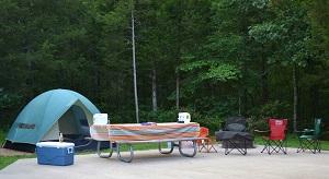 a family sitting around a campfire next to their camper