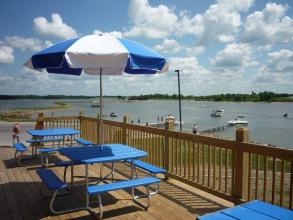 picnic tables with umbrellas on the deck of the marina