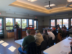 Participants sitting in a conference room watching a speaker