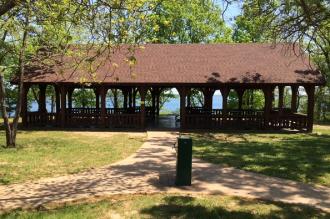 sidewalk leads to water fountain and shelter next to the lake