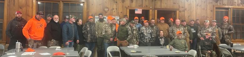 Hunters and guides pose for a photo inside the group camp recreation hall