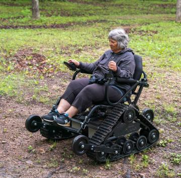 person driving track chair outdoors