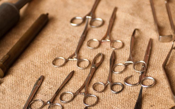 Many scissors sitting on a cloth