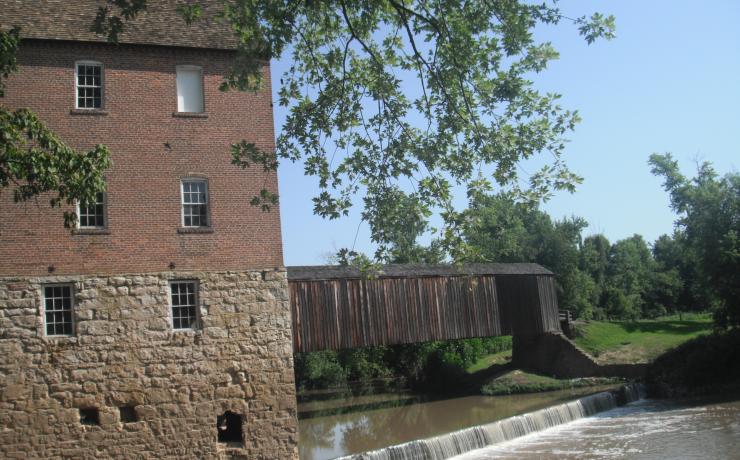 Old covered bridge with an old mill in front of it
