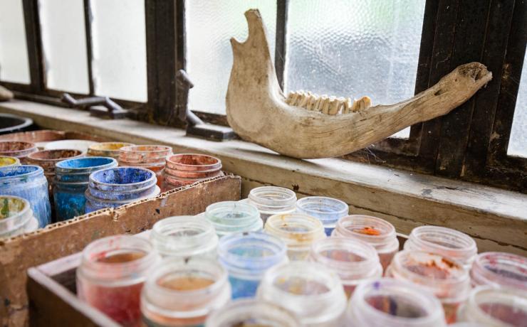 Jars of paints sitting by a window with a jaw bone on the sill