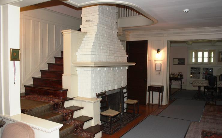 Inside of the Benton home with a white fireplace and stairs leading up