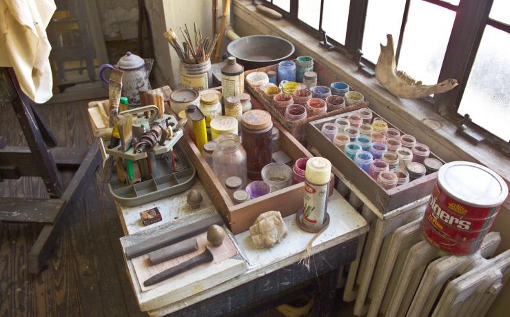 Painting supplies on a desk next to a window