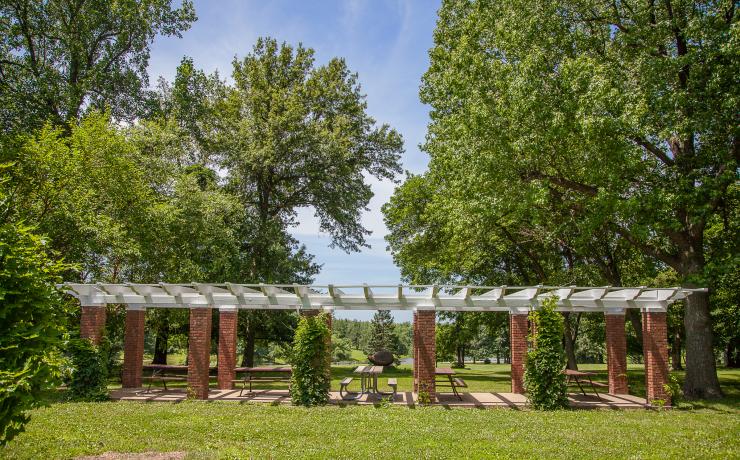 A brick and white-roofed picnic shelter with several picnic tables