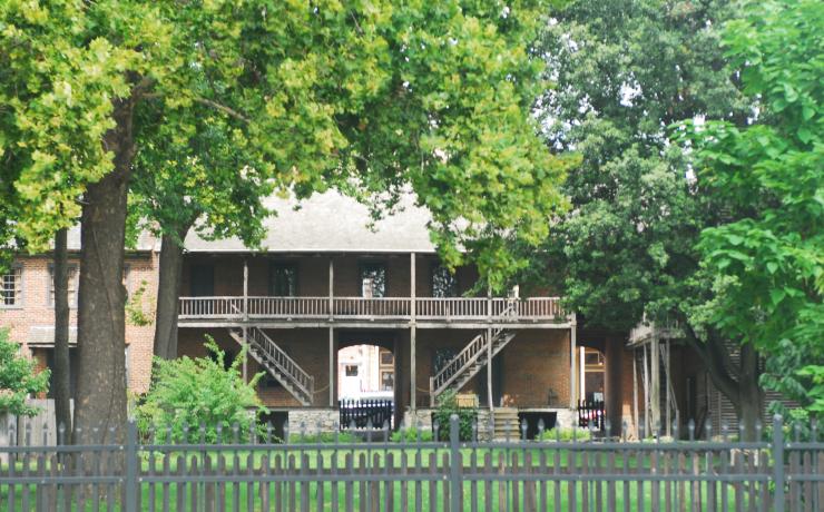 A brick and woode building with a wooden fence around it