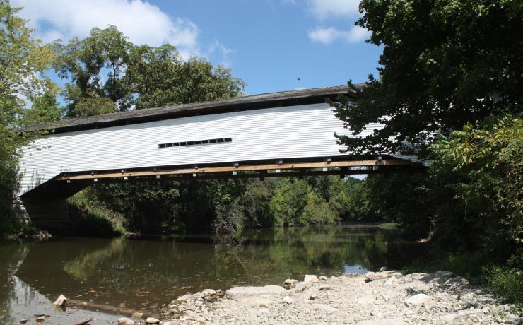 A white covered bridge over a river