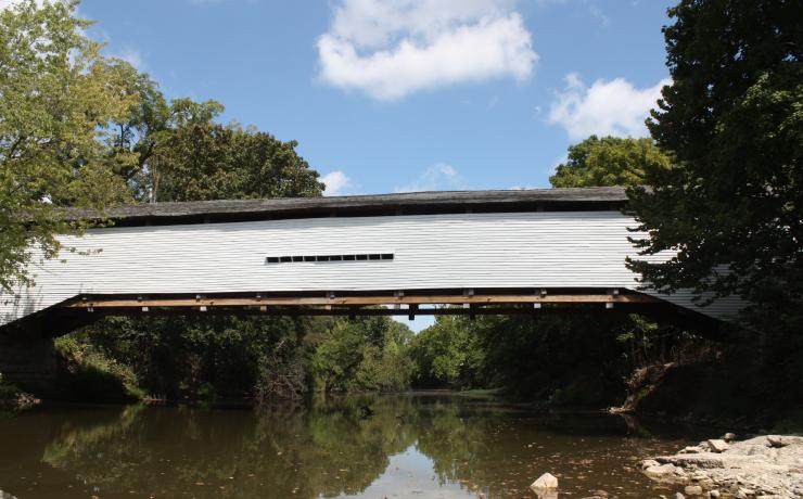 A white covered bridge over a river