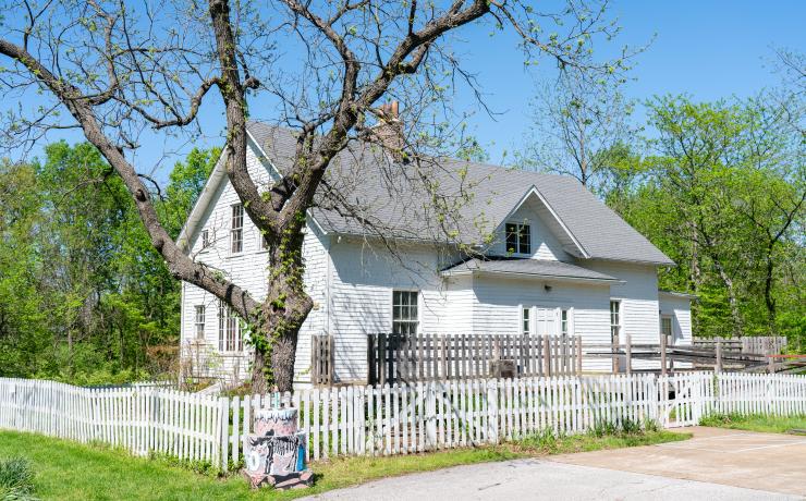 A white house surrounded by a white fence