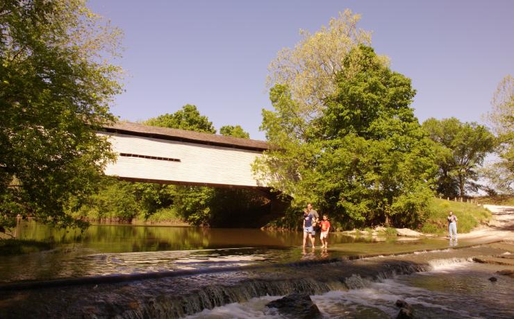 A family walking across a shallow river