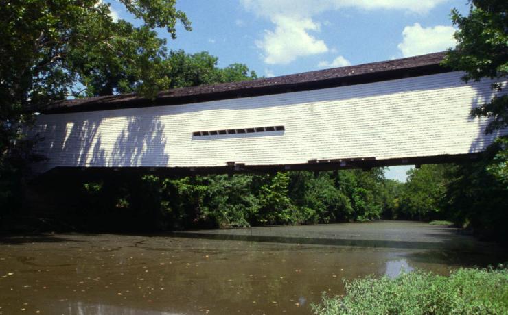 A white covered bridge over a river