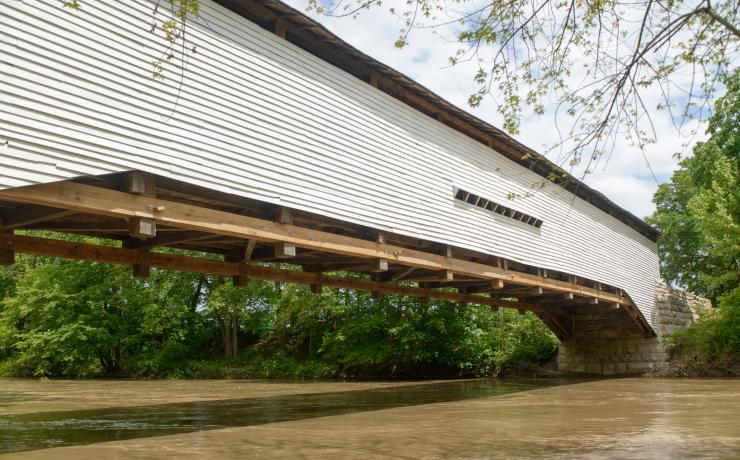 A white covered bridge over a river
