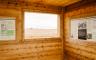 Inside of a wooden cabin with an information board about the Battle of Island Mound