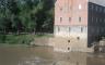 An old brick mill next to a large river