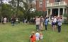 People gathered outside a brick building