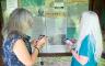 Two women looking at an information board and taking notes