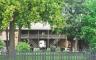 A brick and woode building with a wooden fence around it