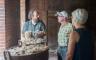 A man showing raw wool to a couple