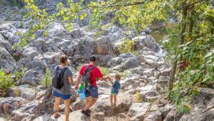 A family walking over rocks
