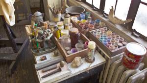 Painting supplies on a desk next to a window