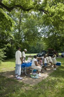 large group gathered at a picnic table enjoying lunch