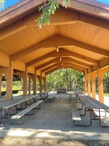 Picnic tables under the roof of the open shelter