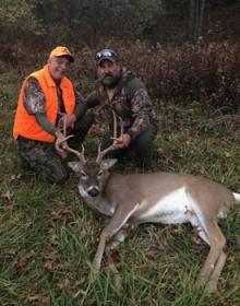 A hunter and guide posing with a deer