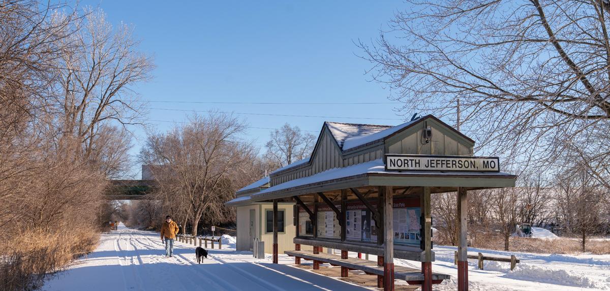 Man and dog walking in the snow on the Katy Trail.