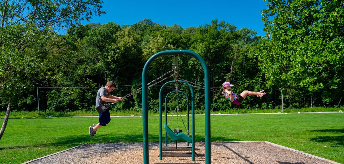 Two children using a swing set