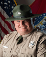 Ranger Andrew McClanahan standing in-front of a flag
