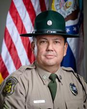 Ranger Todd Bryant standing in-front of a flag