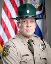 Ranger Josh Campbell standing in-front of flag
