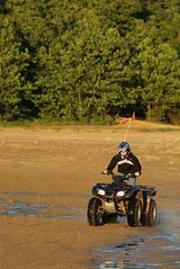 A person driving a 4-wheeler on a dirt track