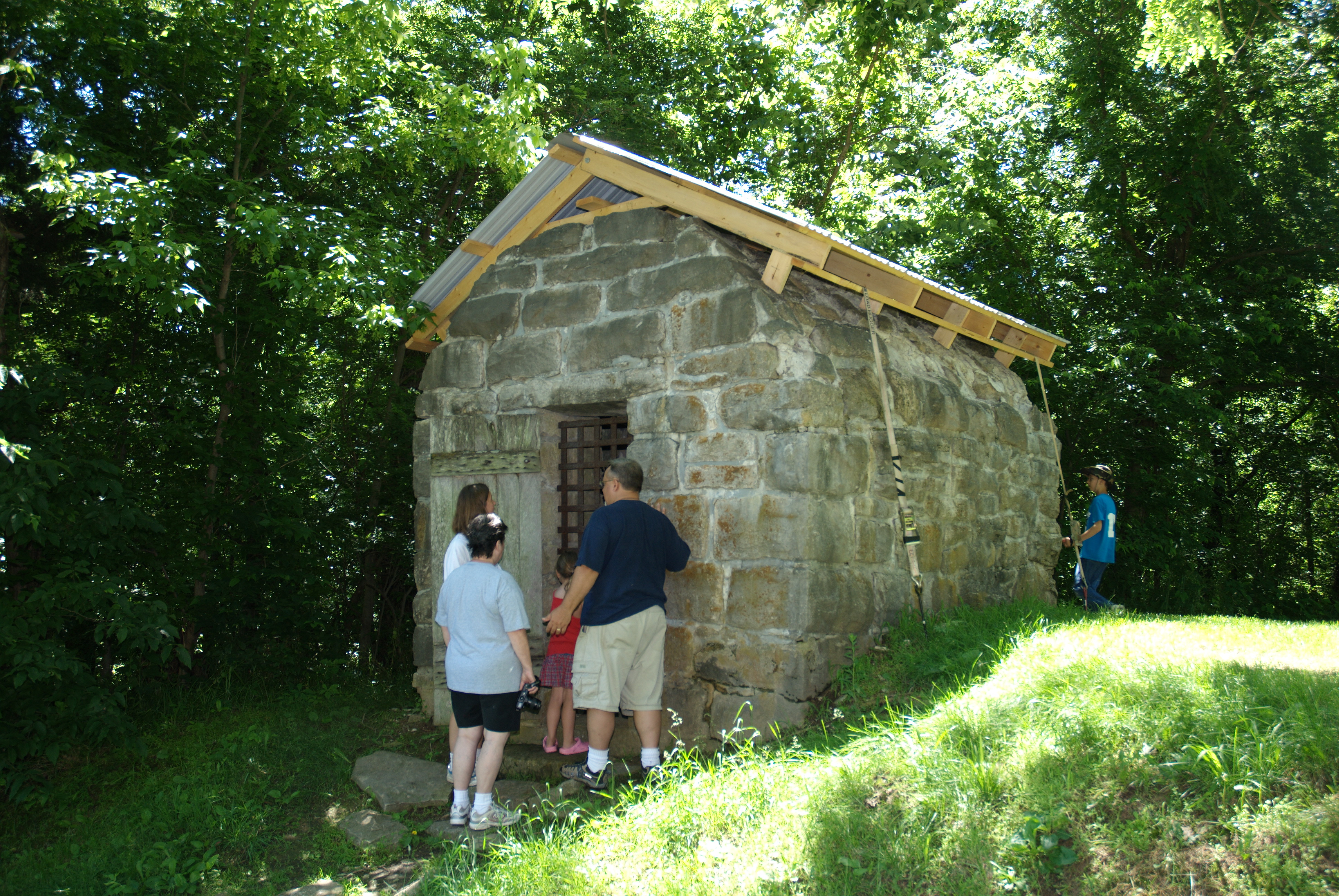 people looking at the small stone jail