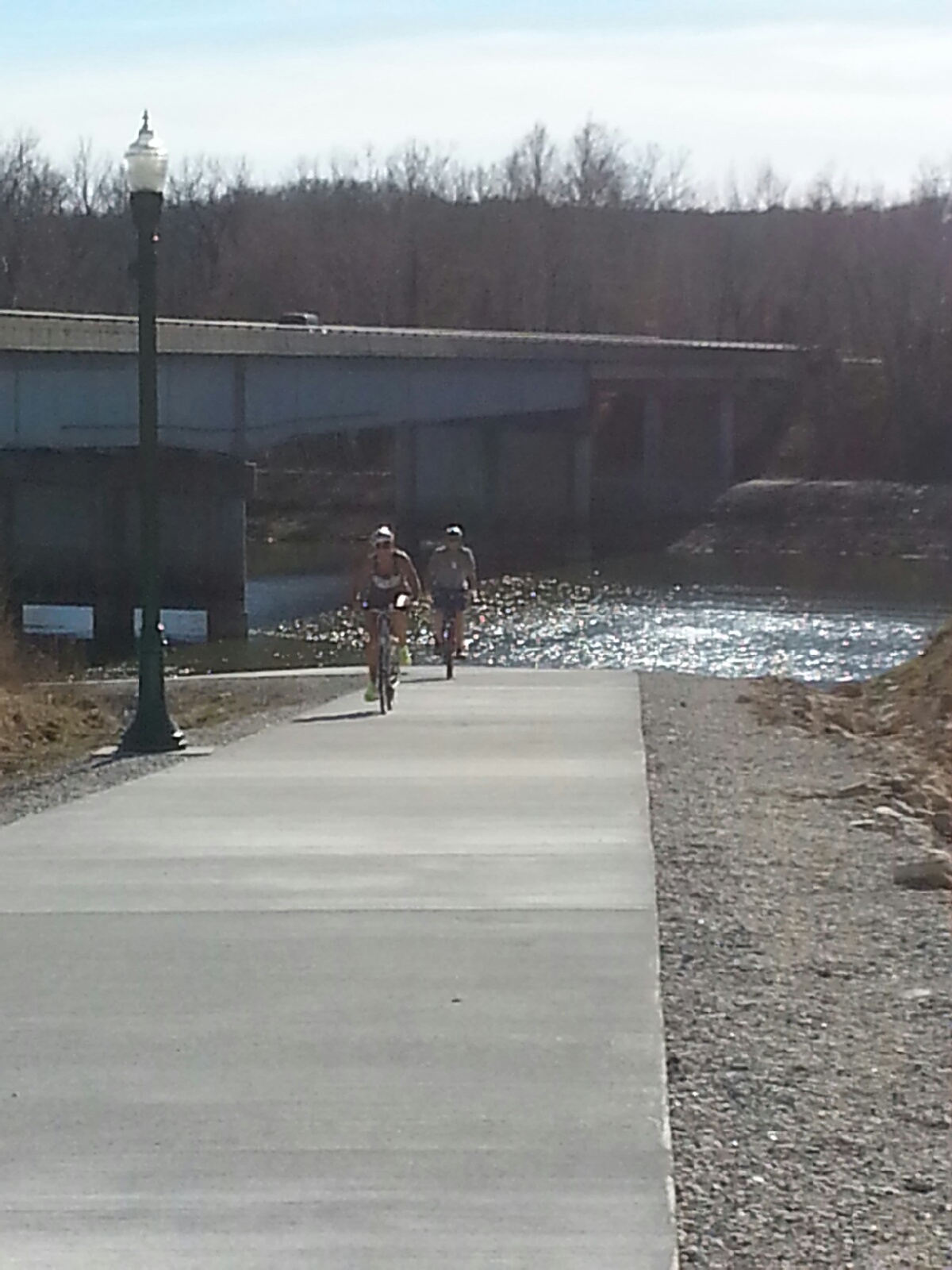 two cyclists on a concrete trail