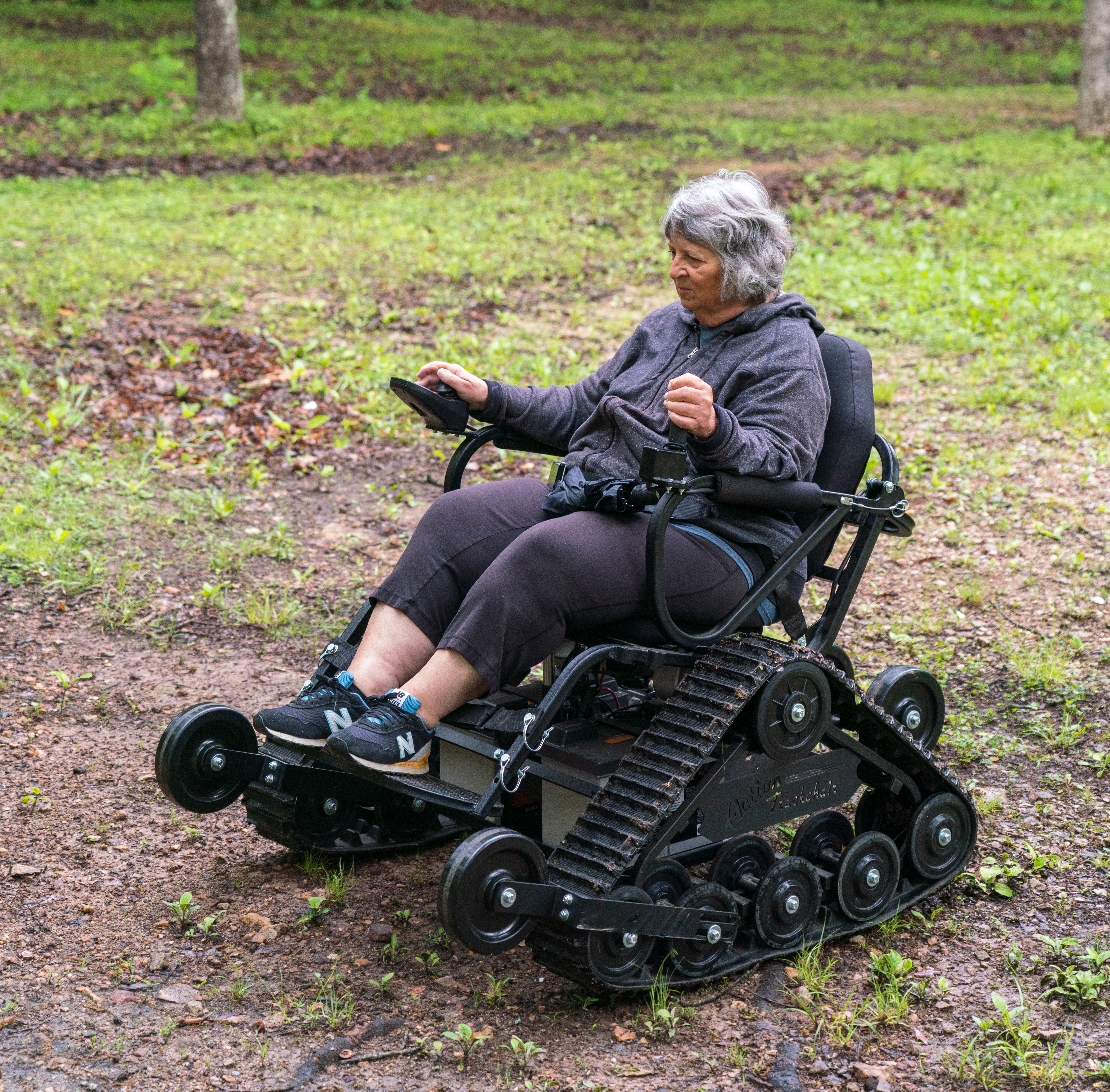 person driving track chair outdoors 