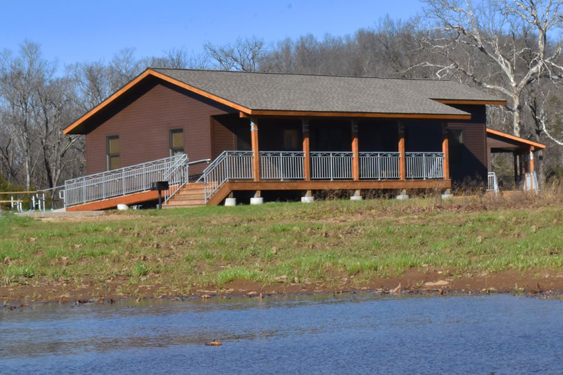 Exterior image of a cabin with brown siding and covered front porch