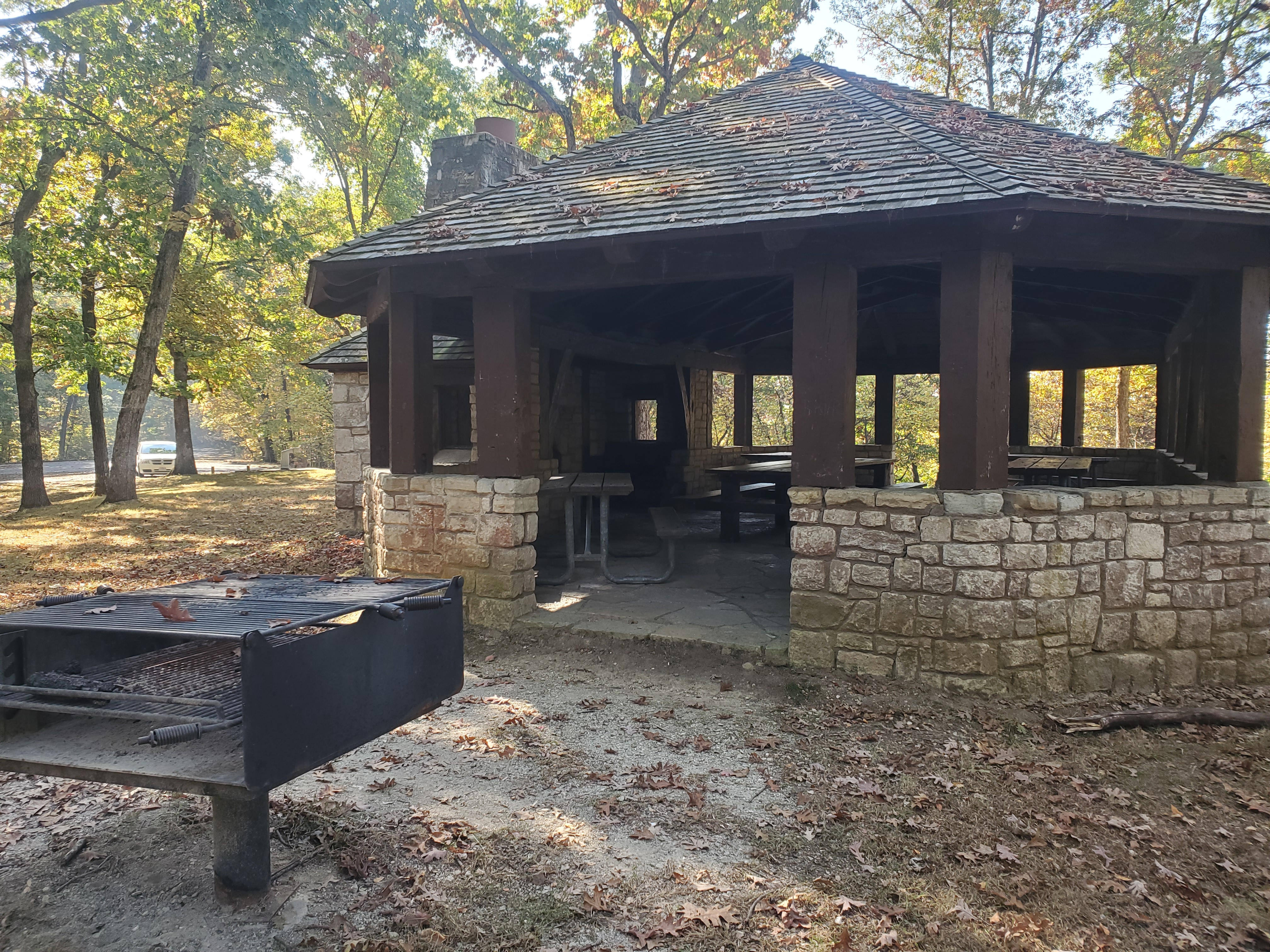 Grill in front of the rock and wood open shelter