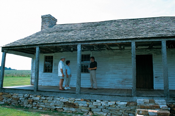 a couple on the front porch of the cabin taking a tour