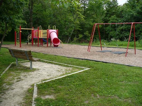bench by the playground with a slide and swings