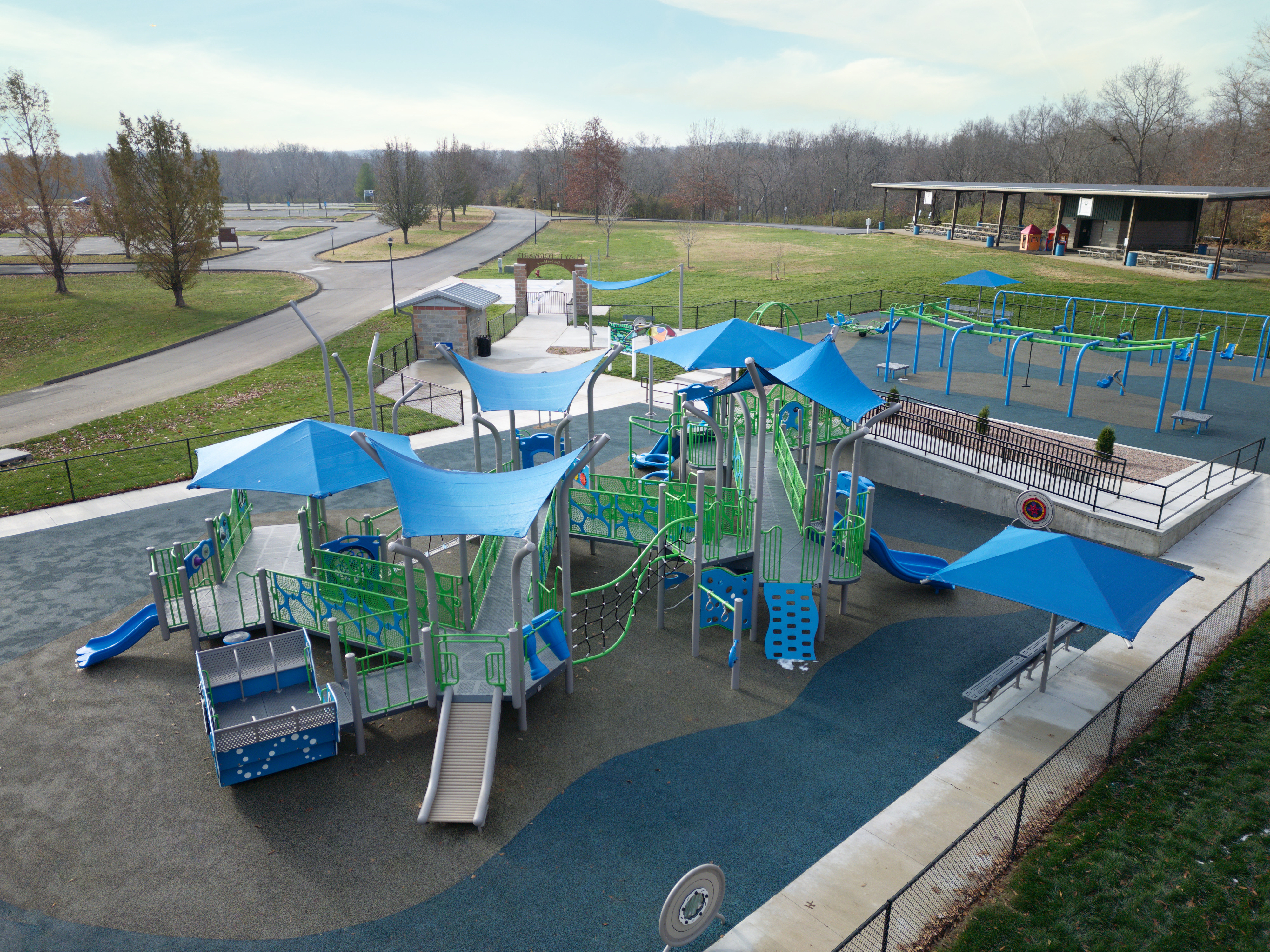 Aerial photo of playground featuring slides, swings, railed walkway and canopies