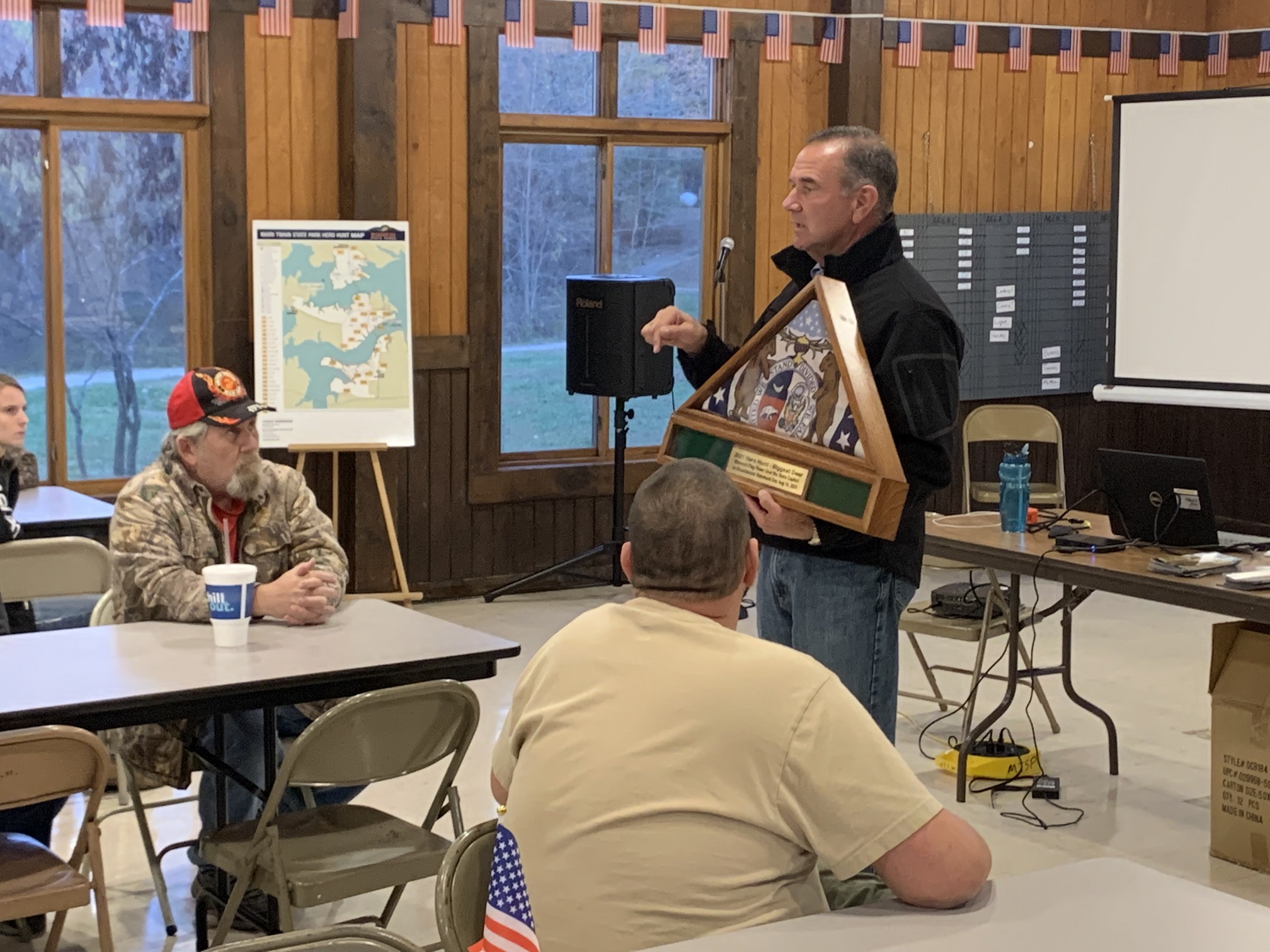 Lt. Gov. Mike Kehoe holds and discusses the Biggest Buck Award, a triangular award with image from the Missouri flag, to be presented after the hunt.