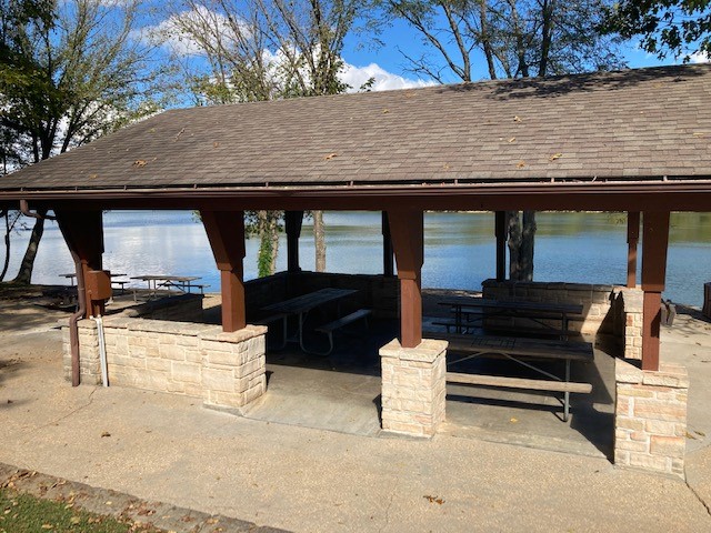 View of the picnic tables under the roof of the open shelter