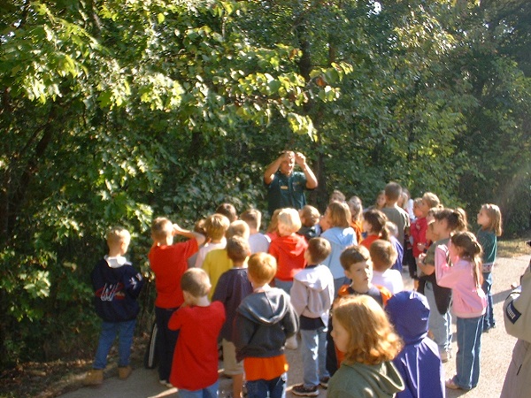 a group of kids listen to the park naturalist