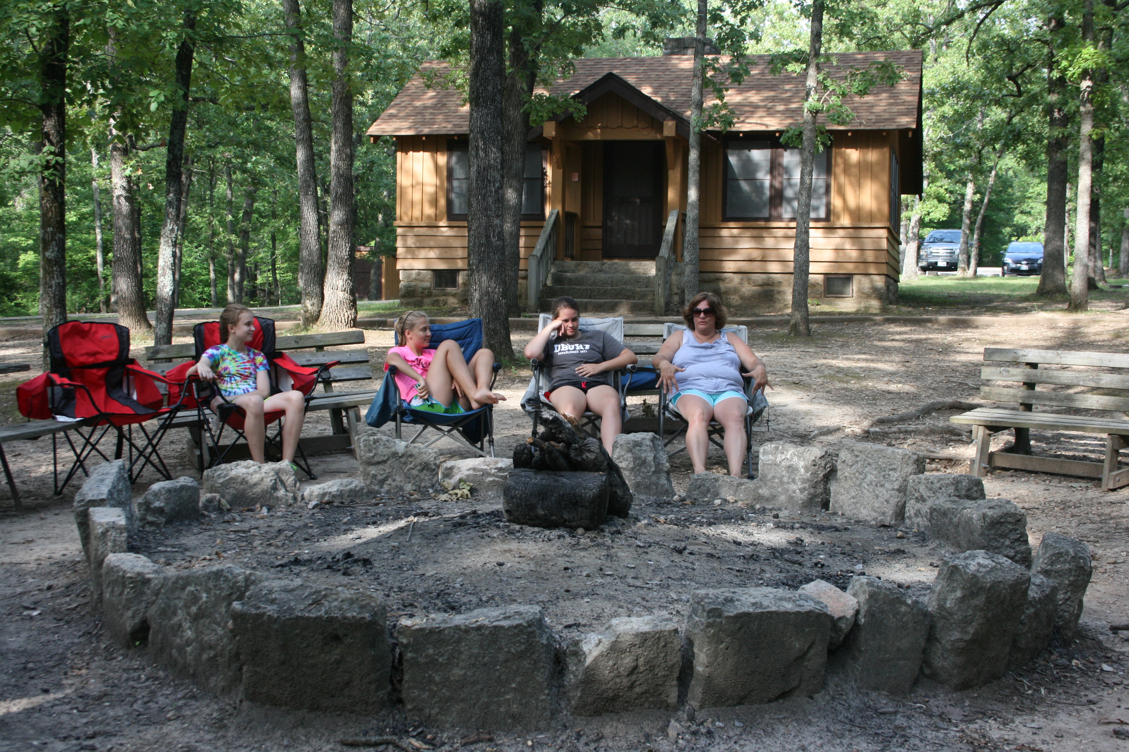 people sitting around the group fire ring